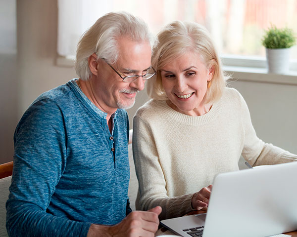 pareja tercera edad revisando información en su computador