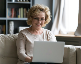 mujer tercera edad revisando información en su computador