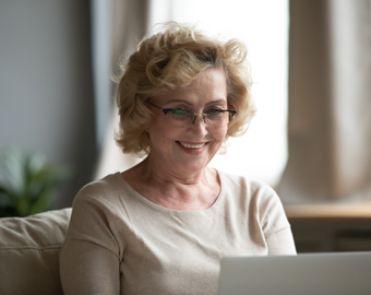 mujer tercera edad revisando información en su computador